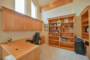 Office area with built in desk and light colored carpet