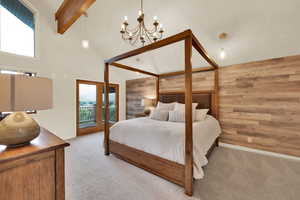 Carpeted bedroom with wooden walls, high vaulted ceiling, beam ceiling, access to outside, and a chandelier
