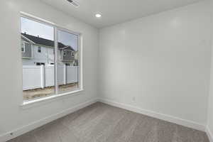Carpeted spare room featuring baseboards