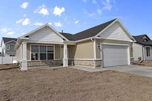 Craftsman-style house featuring stone siding, concrete driveway, a garage, and a shingled roof