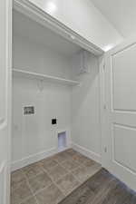 Laundry room with washer hookup, light tile patterned flooring, and electric panel