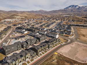 Aerial view of property and surrounding area with mountains and nearby suburban area