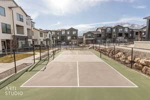 View of tennis court with a residential view