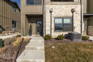 Doorway to property featuring stone siding and board and batten siding