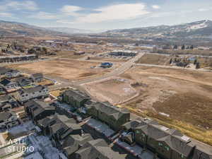 Aerial view of property and surrounding area with nearby suburban area and a mountainous background