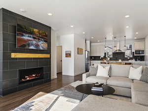 Living area with a fireplace, dark wood finished floors, and recessed lighting