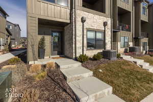 Property entrance with board and batten siding and stone siding