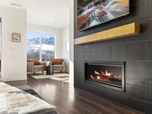 Detailed view of a fireplace, wood finished floors, and recessed lighting