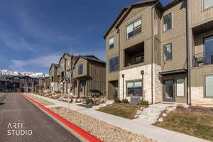 View of asphalt street featuring sidewalks, a residential view, curbs, and a mountain view
