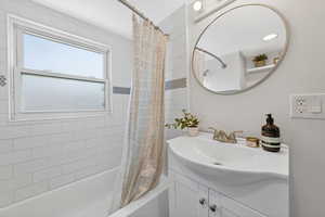 Bathroom with vanity and shower / bath combo with shower curtain