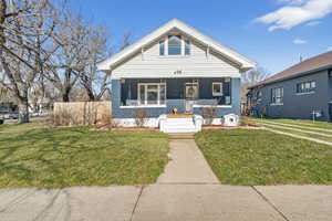 View of front of house featuring covered porch and a front lawn