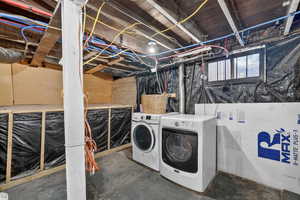 Laundry area with washing machine and dryer and unfinished concrete flooring