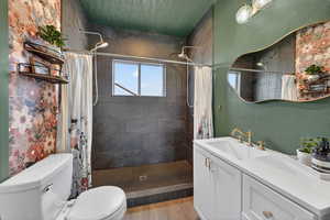 Full bath with a shower stall, vanity, and light wood-style floors