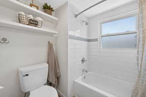 Bathroom featuring shower / bath combo with shower curtain and toilet
