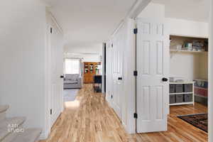 Hallway with light wood finished floors and stairs
