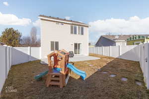 Back of house with a patio area, a fenced backyard, and a playground