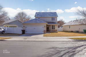Traditional-style home featuring concrete driveway, an attached garage, a shingled roof, and stucco siding