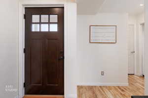 Foyer entrance with light wood finished floors and baseboards