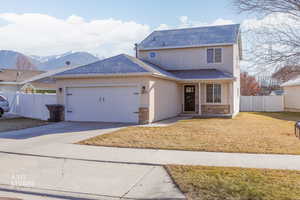 Traditional-style home featuring a shingled roof, driveway, a mountain view, a garage, and stucco siding