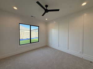 Unfurnished room with light carpet, a decorative wall, ceiling fan, and recessed lighting