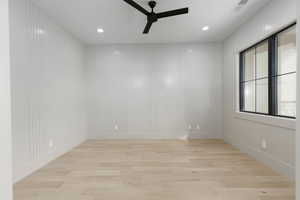 Unfurnished room featuring light wood finished floors, ceiling fan, recessed lighting, and a decorative wall