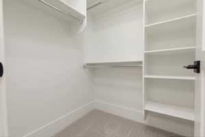 Walk in closet with light carpet