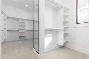 Walk in closet featuring light carpet