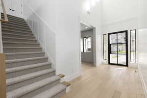 Entryway with light wood finished floors and a high ceiling