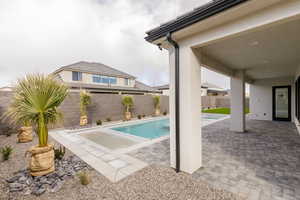 View of pool with patio surround and a fenced backyard