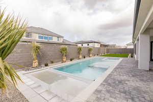 View of swimming pool with a fenced backyard and patio surround