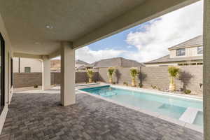 View of pool with patio surround and a fenced backyard