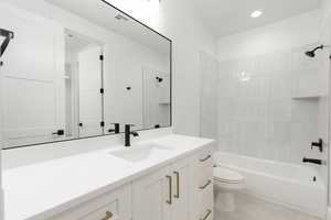 Bathroom featuring vanity, shower / bathtub combination, and recessed lighting