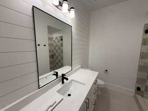 Bathroom with vanity, a shower stall, and wooden walls