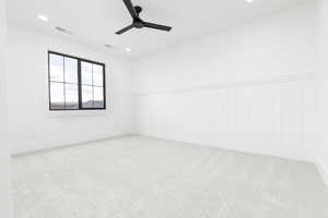 Empty room with light colored carpet, a ceiling fan, recessed lighting, and a wainscoted wall