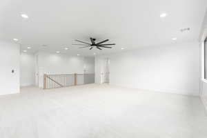 Empty room with light colored carpet, a ceiling fan, and recessed lighting