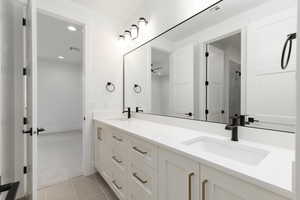 Bathroom featuring double vanity, light colored carpet, recessed lighting, and light tile patterned flooring
