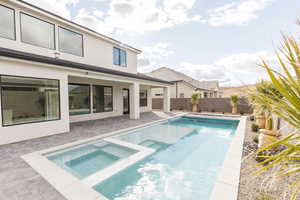 Integrated pool / hot tub featuring a patio area and a fenced backyard