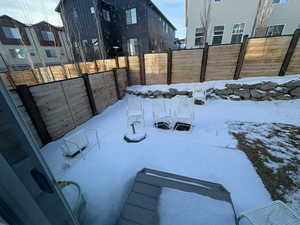 Snowy yard featuring a fenced backyard