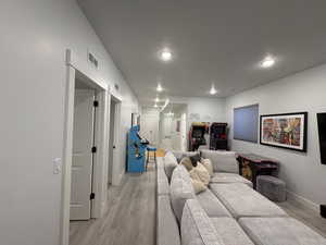 Living area featuring light wood finished floors and recessed lighting