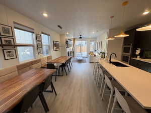 Dining room with a ceiling fan, light wood-style flooring, a textured ceiling, and recessed lighting