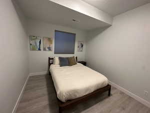 Bedroom featuring baseboards and wood finished floors