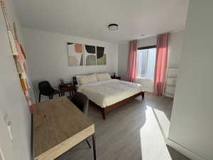 Bedroom featuring wood finished floors and baseboards