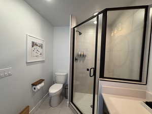 Full bathroom with light tile patterned floors, a shower stall, vanity, and a textured ceiling