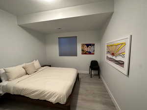 Bedroom featuring wood finished floors and a textured ceiling