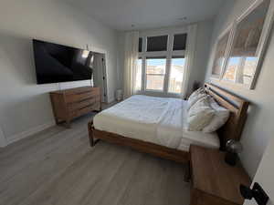 Bedroom featuring wood finished floors and baseboards