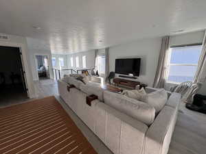 Living room with a textured ceiling and wood finished floors