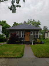 Bungalow-style home with a front lawn and a chimney
