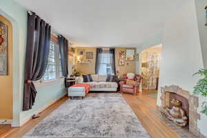 Living area with arched walkways and light wood-style floors