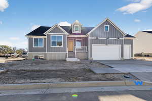 View of front of house featuring driveway, a porch, an attached garage, and board and batten siding