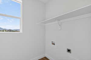 Laundry area with hookup for an electric dryer, hookup for a washing machine, and wood finished floors